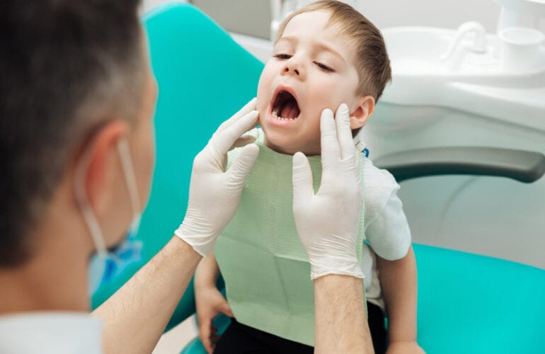 Kids Dentist Preparing child for teeth extraction