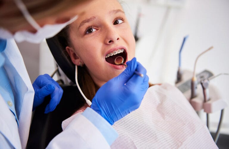 orthodontist examining childs teeth